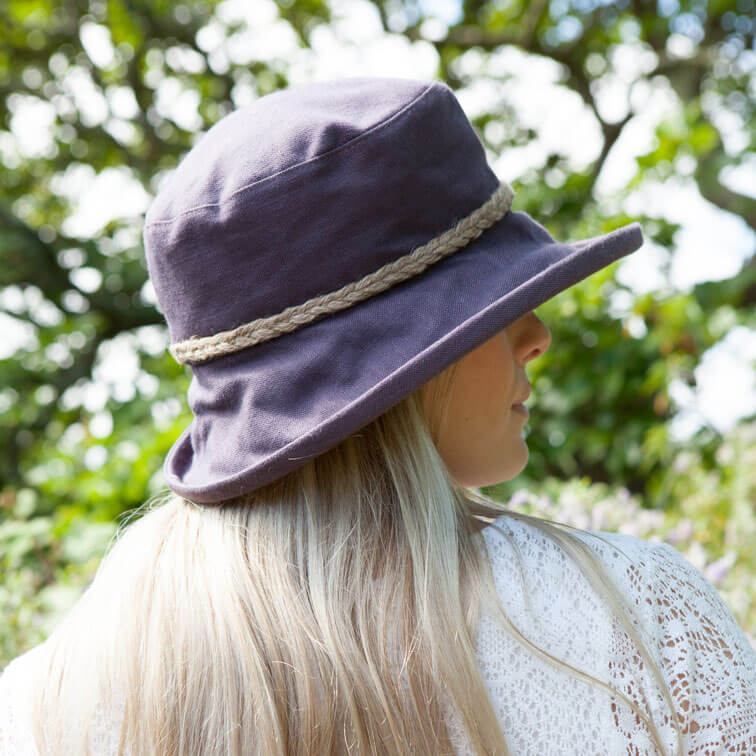 lady wearing aubergine coloured linen sun hat with natural cord trim on crown of hat 